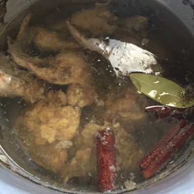 Pot of fresh chicken stock with cinnamon and bay leaves